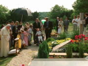 FILE - In this Aug.22, 1997 file photo, Pope John Paul II meditates by the grave of his former friend geneticist Jerome Lejeune, during a private visit to the Chalo-Saint-Mars cemetery near Paris. Pope Francis on Thursday, Jan. 21, 2021, approved the &quot;heroic virtues&quot; of Dr. Jerome Lejeune, who discovered the genetic basis of Down syndrome, lived from 1926-1994 and was particularly esteemed by St. John Paul II for his anti-abortion stance.