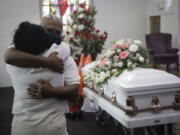 FILE - In this July 21, 2020, file photo, Darryl Hutchinson, facing camera, is hugged by a relative during a funeral service for Lydia Nunez, who was Hutchinson&#039;s cousin at the Metropolitan Baptist Church in Los Angeles. Nunez died from COVID-19. Southern California funeral homes are turning away bereaved families because they&#039;re running out of space for the bodies piling up during an unrelenting coronavirus surge.