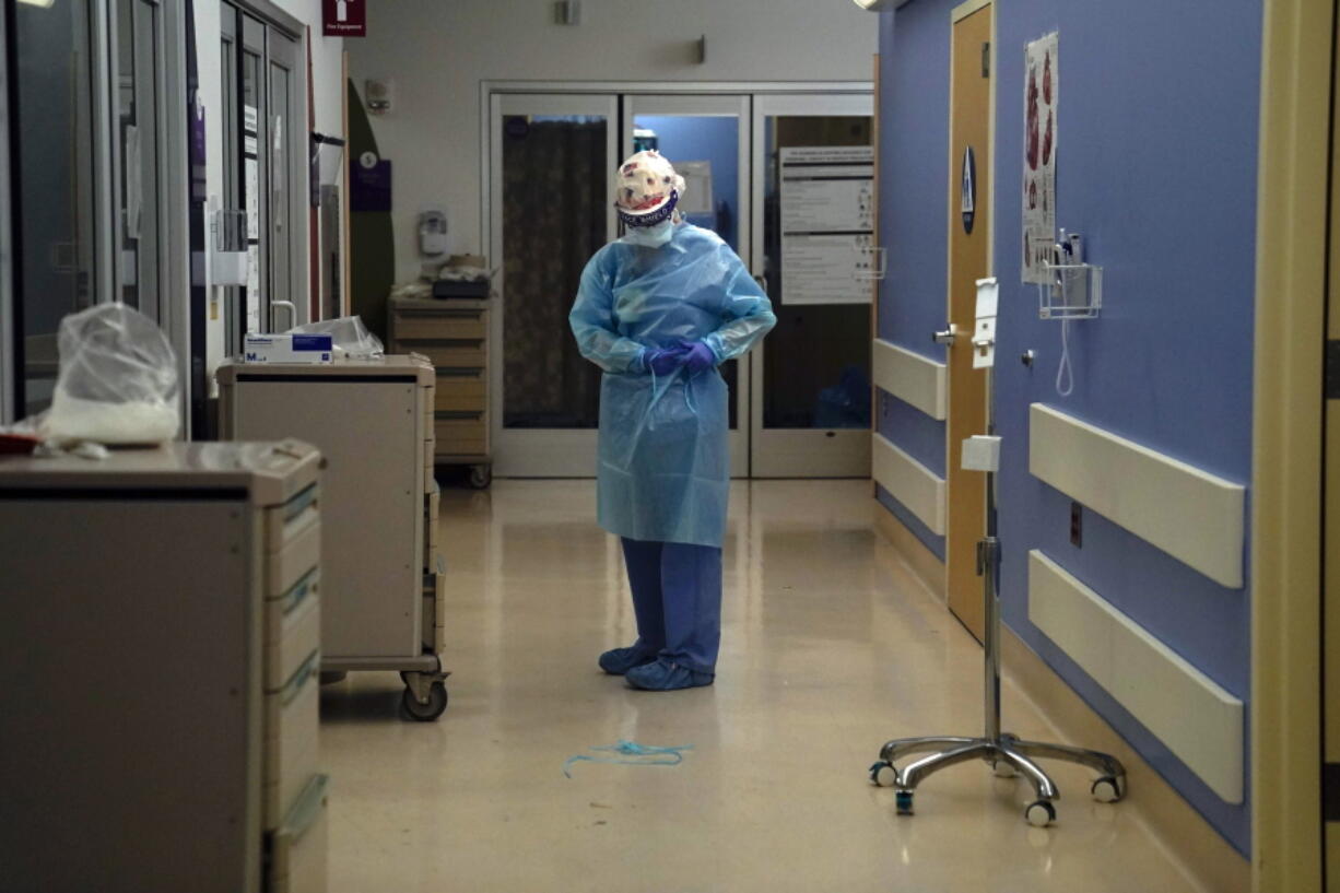 FILE - In this Jan. 7, 2021, file photo, a nurse puts on protective gear in a COVID-19 unit in California. The nation&#039;s biggest immunization rollout in history is facing pushback from an unlikely source: health care workers who witnessed COVID-19?s devastation firsthand but are refusing shots in surprising numbers. (AP Photo/Jae C.