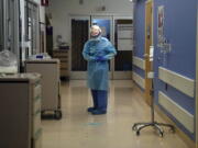 FILE - In this Jan. 7, 2021, file photo, a nurse puts on protective gear in a COVID-19 unit in California. The nation&#039;s biggest immunization rollout in history is facing pushback from an unlikely source: health care workers who witnessed COVID-19?s devastation firsthand but are refusing shots in surprising numbers. (AP Photo/Jae C.