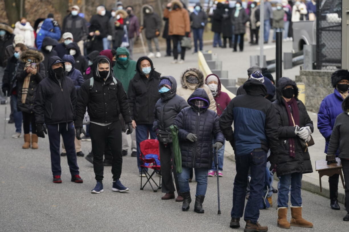 FILE - In this Jan. 21, 2021, file photo, people wait in line for the COVID-19 vaccine in Paterson, N.J. A racial gap has opened up in the nation&#039;s COVID-19 vaccination drive, with Black Americans in many places lagging behind whites in receiving shots, an Associated Press analysis shows.