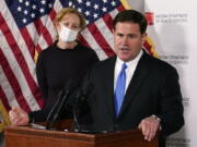 FILE - In this Dec. 2, 2020, file photo, Arizona Gov. Doug Ducey answers a question about the arrival of a COVID-19 vaccine in Arizona, while Arizona Department of Health Services Director Dr. Cara Christ listens in Phoenix. As Arizona experienced periodic spikes in COVID-19 cases since last spring, Ducey frequently resisted calls to take strong measures. He has declined to institute a statewide mask mandate, allowed school districts to mostly make their own choices and allowed businesses to stay open. All of those choices by the Republican governor are now getting renewed scrutiny as the Grand Canyon state becomes what health officials call the latest &quot;hot spot of the world&quot; because of soaring case loads. (AP Photo/Ross D.