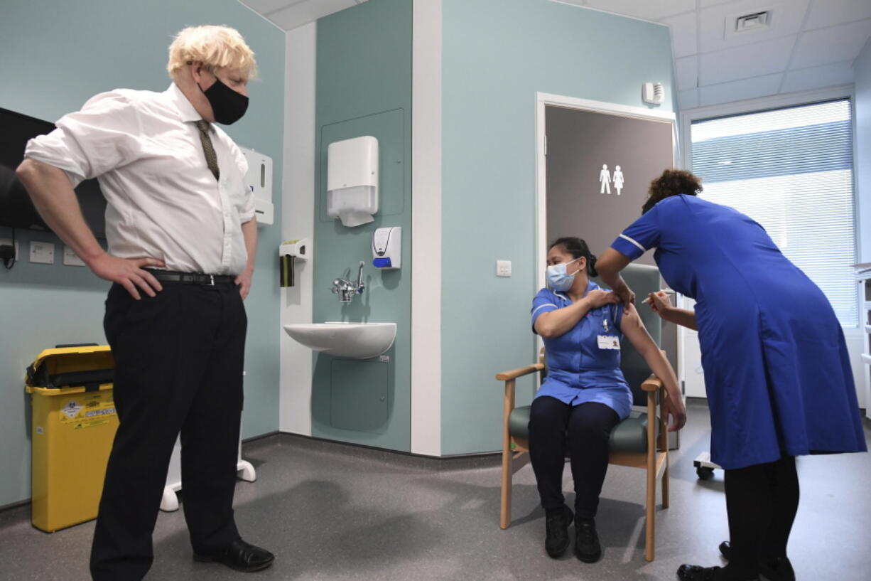 Britain&#039;s Prime Minister Boris Johnson watches as nurse Jennifer Dumasi is injected with the Oxford-AstraZeneca Covid-19 vaccine, during a visit to view the vaccination programme at the Chase Farm Hospital in north London, Monday Jan. 4, 2021, part of the Royal Free London NHS Foundation Trust.