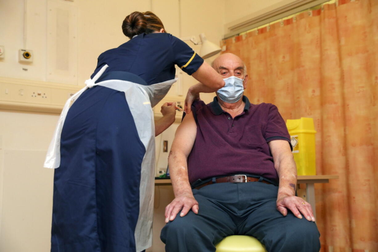 82-year-old Brian Pinker receives the Oxford University/AstraZeneca COVID-19 vaccine from nurse Sam Foster at the Churchill Hospital in Oxford, England, Monday, Jan. 4, 2021. Pinker, a retired maintenance manager received the first injection of the new vaccine developed by between Oxford University and drug giant AstraZeneca.