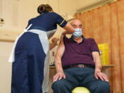 82-year-old Brian Pinker receives the Oxford University/AstraZeneca COVID-19 vaccine from nurse Sam Foster at the Churchill Hospital in Oxford, England, Monday, Jan. 4, 2021. Pinker, a retired maintenance manager received the first injection of the new vaccine developed by between Oxford University and drug giant AstraZeneca.