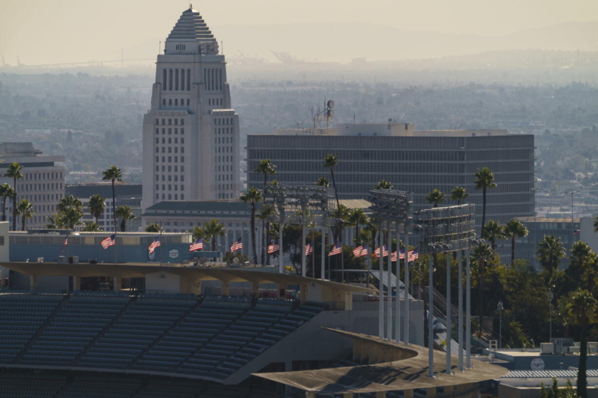 Flags fly half-mast at Dodgers Stadium in honor of the recent passing of the Hall of Fame manager Tommy Lasorda overlooking Los Angeles City Hall Monday, Jan. 11, 2021. Dodger Stadium, the home stadium of Major League Baseball&#039;s Los Angeles Dodgers holds 56,000 spectators. The The coronavirus death toll in California reached 30,000 on Monday, another staggering milestone as the nation&#039;s most populous state endures the worst surge of the nearly yearlong pandemic.