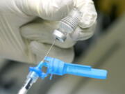 FILE - In this Dec. 16, 2020, file photo, a registered nurse prepares a syringe with the first round of the Pfizer COVID vaccination in Ridgeland, Miss., as state medical leaders received inoculations. On Friday, Dec. 18, 2020, The coronavirus vaccines have been rolled out unevenly across the U.S., but some states in the Deep South have had particularly dismal inoculation rates. (AP Photo/Rogelio V.