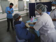 Health workers participate in a COVID-19 vaccine delivery system trial in Hyderabad, India, Saturday, Jan. 2, 2021. India tested its COVID-19 vaccine delivery system with a nationwide trial on Saturday as it prepares to roll-out an inoculation program to stem the coronavirus pandemic.