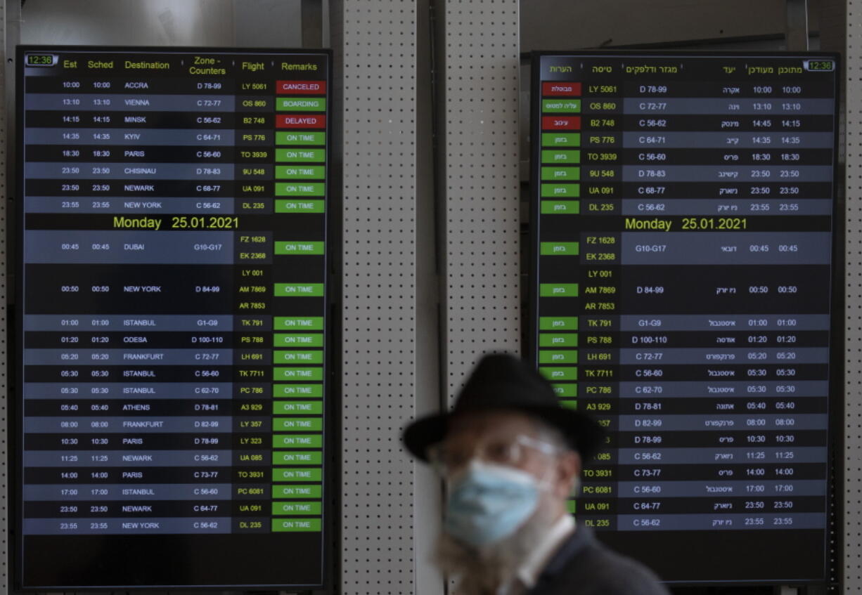 A passenger wears a face mask to protect from coronavirus in the departure hall in Ben Gurion Airport near Tel Aviv, Israel, Sunday, Jan. 24, 2021 during a nationwide lockdown to curb the spread of the virus COVID-19. Prime Minister Benjamin Netanyahu on Sunday said Israel was closing its international airport to nearly all flights as the government races to bring a raging coronavirus outbreak under control.