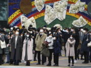 People wearing protective masks to help curb the spread of the coronavirus wait for traffic light to walk along pedestrian crossings in the Shibuya area of Tokyo Tuesday, Jan. 5, 2021. Japanese Prime Minister Yoshihide Suga says vaccine approval is being speeded up to curb the spread of the coronavirus, and he promised to consider declaring a state of emergency. The Japanese capital confirmed more than 1200 new coronavirus cases on Tuesday.