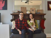 In this photo provided by Kate Hilts, Ross Hettervig, left, and Kate Hilts pose for a photo with their cat, Potato, on Nov. 14, 2020, in Washington. Veterinarians and owners report some pets are being medicated for anxiety, and others are being put on diets because of too many treats and not enough exercise in parks that humans may be avoiding because of virus concerns. Hilts says her cat, a rescue who joined their household in March 2019, always seemed to enjoy attention from strangers but now hides from visitors.