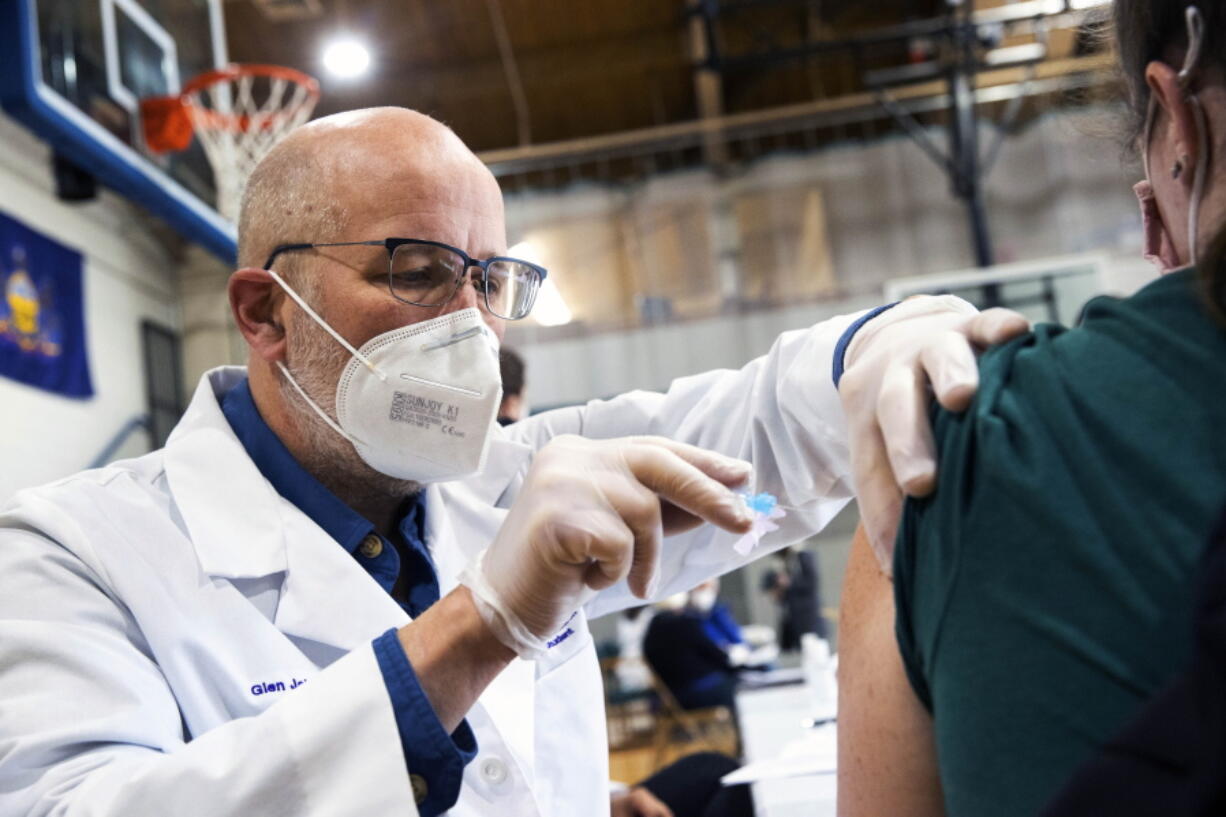 University of Scranton nursing student Glen Johnson administers the Moderna COVID-19 vaccine to a medical professional during a clinic at the Throop Civic Center in Throop, Pa. on Saturday, Jan. 9, 2021. The Lackawanna County Medical Society had about 400 doses of the Moderna vaccine on hand to administer to people in Pennsylvania&#039;s Phase 1A group of the vaccine rollout plan, which is limited to healthcare personnel and long-term care facility residents.