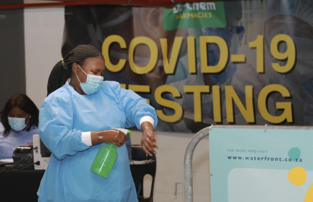 A health-care worker sanitises her hands before conducting COVID-19 tests at a Dis-Chem drive-through testing station at the V&amp;A Waterfront in Cape Town, South Africa, Friday, Jan. 8, 2021. South Africa with 60 million people has reported by far the most cases of the coronavirus in Africa, with more than 1.1 million confirmed infections.