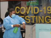 A health-care worker sanitises her hands before conducting COVID-19 tests at a Dis-Chem drive-through testing station at the V&amp;A Waterfront in Cape Town, South Africa, Friday, Jan. 8, 2021. South Africa with 60 million people has reported by far the most cases of the coronavirus in Africa, with more than 1.1 million confirmed infections.