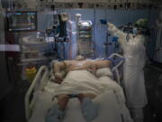 A COVID-19 patient receives treatment in the ICU of the Hospital del Mar, in Barcelona, Spain, Tuesday, Jan. 19, 2021. The unrelenting increase in COVID-19 infections in Spain following the holiday season is again straining hospitals, threatening the mental health of doctors and nurses who have been at the forefront of the pandemic for nearly a year.