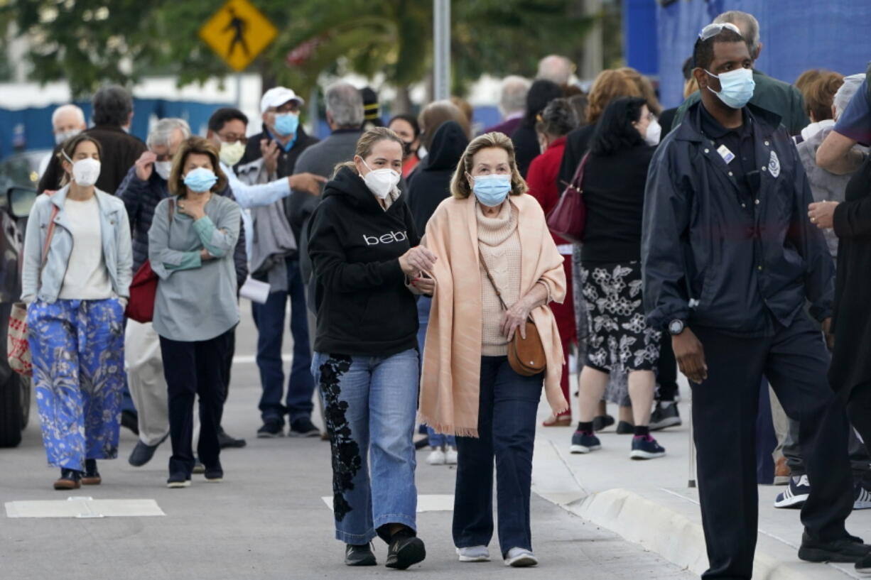 FILE - In this Jan. 6, 2021, file photo, people arrive at Jackson Memorial Hospital to receive the COVID-19 vaccine in Miami. With frustration rising over the slow rollout of the vaccine, state leaders and other politicians are turning up the pressure, improvising and seeking to bend the rules to get shots in arms more quickly.