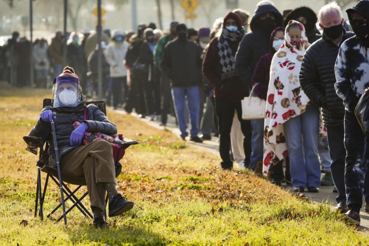 FILE - In this Jan. 11, 2021, file photo, Florence Mullins, 89, sits in a chair as a family member holds her place in a long line to receive a COVID-19 vaccine at Fair Park in Dallas. Uncertainty over the pace of federal COVID-19 vaccine allotments triggered anger and confusion Friday, Jan. 15, 2021, in some states where officials worried that expected shipments would not be forthcoming.  (Smiley N.