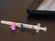 A syringe with the Moderna coronavirus vaccine is displayed at a clinic.