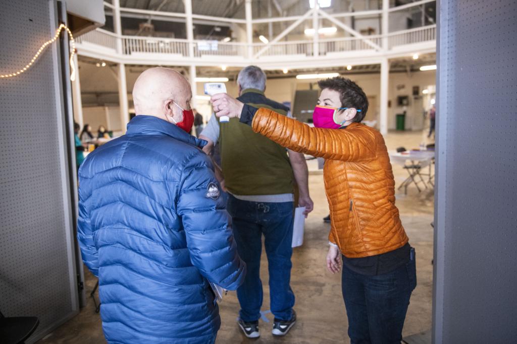 Nikki Sharp takes temperatures at a mass vaccination clinic at the Walla Walla Fairgrounds pavilion Saturday, Jan. 23, 2020, in Walla Walla, Wash.