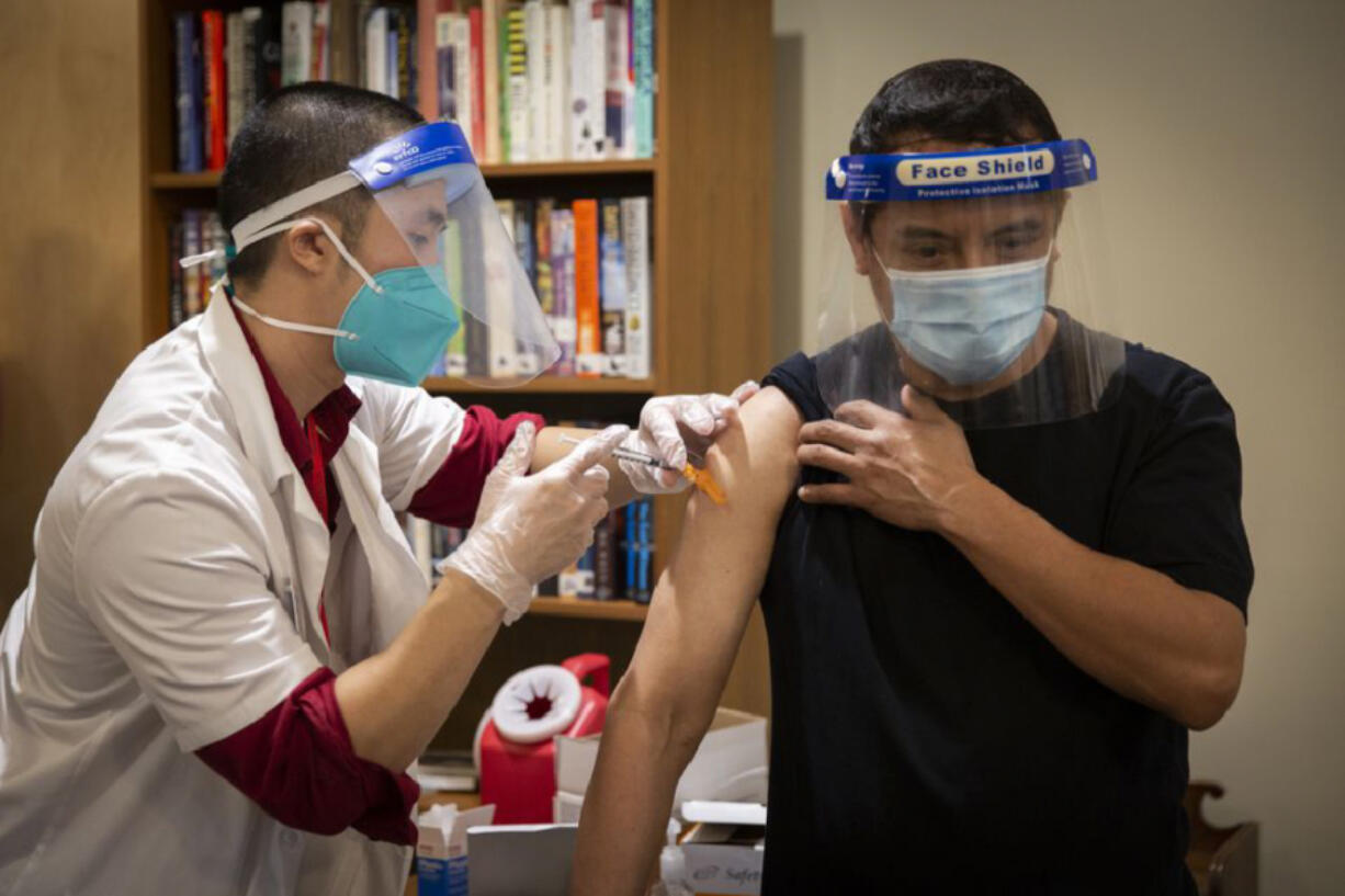 A CVS staff member administers the Pfizer COVID-19 vaccine Dec. 21 at Rose Villa Senior Living in Oak Grove, Ore., just outside of Portland.