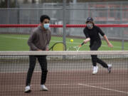 Mountain View senior Nathaniel John, left, watches his Skyview opponents while senior Bryce Penick hits a return in a 3A/4A Greater St. Helens League boys tennis match on Monday at Union High School. Monday was the first time in 333 days that local high school sports held competitions.