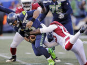 Seattle Seahawks quarterback Russell Wilson, left, is sacked by Arizona Cardinals&#039; Chandler Jones, right, during the first half of an NFL football game, Sunday, Dec. 30, 2018, in Seattle.