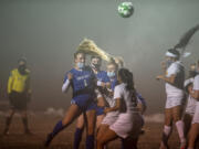 Ridgefield&#039;s Elizabeth Farley, left, rises up to head the ball over Hudson&#039;s Bay defenders in a soccer match on Thursday at Ridgefield High School.