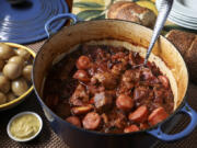 Pork simmers in a Dutch oven or slow cooker with cabbage and sauerkraut. Kielbasa is added near the end of cooking.