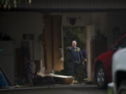 Officials look over the scene after a person reportedly drove through a garage on Northeast 98th Avenue, out the back fence and across Marrion School Park before abandoning the vehicle nearby Friday morning, Feb. 18, 2021. Police are still looking for the driver.