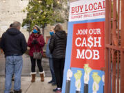 Sunrise Rotary Club members chat underneath a covered area during their cash mob event on Tuesday afternoon at the Columbia Food Park in downtown Vancouver. The group meets at a local restaurant each week to support small businesses.