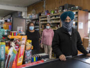 Priscilla Mosby of Amboy Market, from left, pauses for a portrait with Gurvinder Sarai, and her husband, Bharwinder Singh, the store&#039;s owner. Singh moved from India to America once he was an adult for better opportunity.