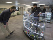 Damian Thomas of Vancouver, left, looks over the selection at the new Craft Cannabis location in northeast Vancouver while assisted by budtender Anthony Taylor during the shop&#039;s soft opening on Friday.