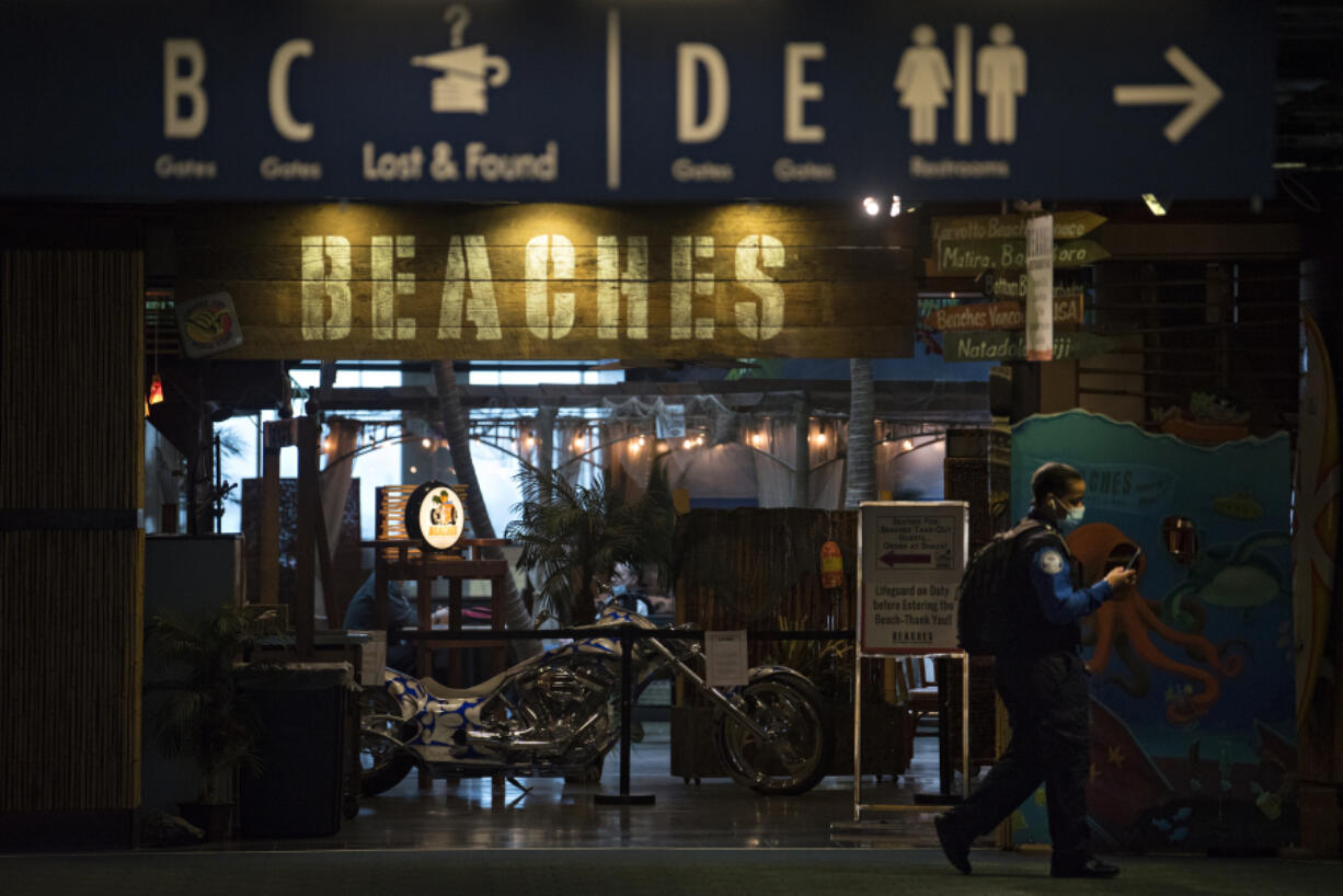 TSA Officer Raven Moore walks past the exterior of Beaches restaurant at Portland International Airport on Thursday morning. Beaches at the airport is closing at the end of March because the airport is being remodeled. The restaurant might not reopen after.