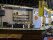 Alcohol bottles sit on shelves behind the countertop at Woody&#039;s Tacos downtown location.