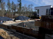 Reynaldo Sotelo, left, and Simeon Chavez of Gecho Construction lend a hand at a home being built at Parklands at Camas Meadows. The home under construction will be 8,000 square feet, part of a trend toward physically larger homes during the pandemic.