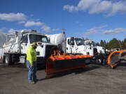 LEADOPTION Richard Harris of the Clark County Public Works Department walks past trucks used for plowing and deicing streets as crews get ready for the possibility of snow accumulation Wednesday afternoon, Feb. 10, 2021.