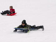 Madden Dreier, 6, slides headfirst on Saturday morning while playing in the snow at Sorenson Park in Felida.