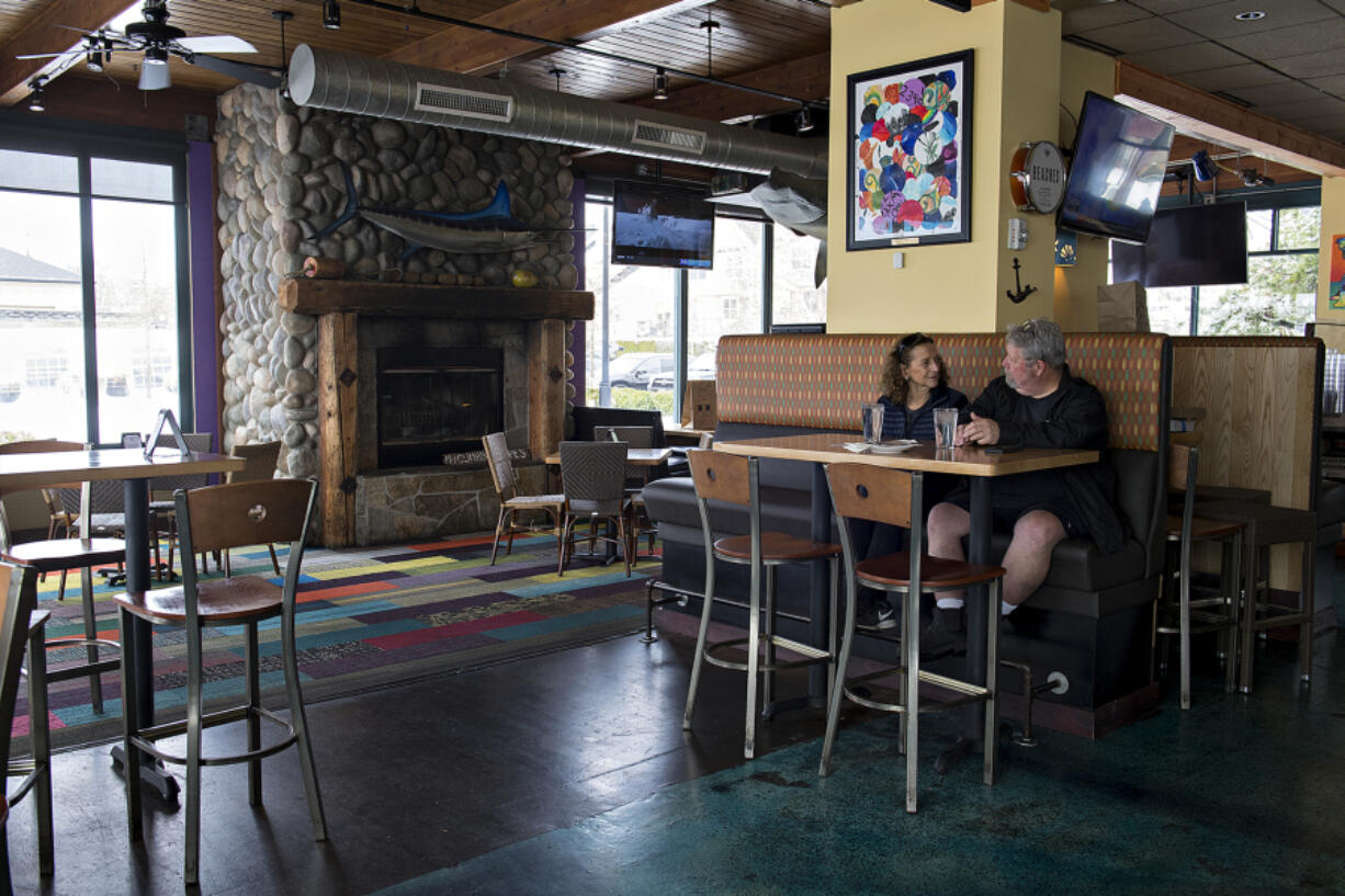 Sherry and Scott Petersen of Vancouver wait for their order near closed windows at Beaches on Monday. Restaurants were allowed to move to Phase 2 of Washington's reopening plan on Sunday, which allows for indoor dining at 25 percent capacity. Phase 1 only allowed indoor dining if a restaurant had sufficient ventilation, which in practice made it very difficult to stay comfortable during the winter.