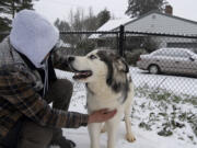 Edgar Lopez pets his dog, Asher, on Friday, February 12, in the Minnehaha neighborhood. Snow continued to accumulate Friday morning as the winter storm persisted.