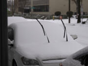 Windshield wipers rise through a couple of inches of snow on a parked car on Friday afternoon, February 12, 2021 in downtown Vancouver.