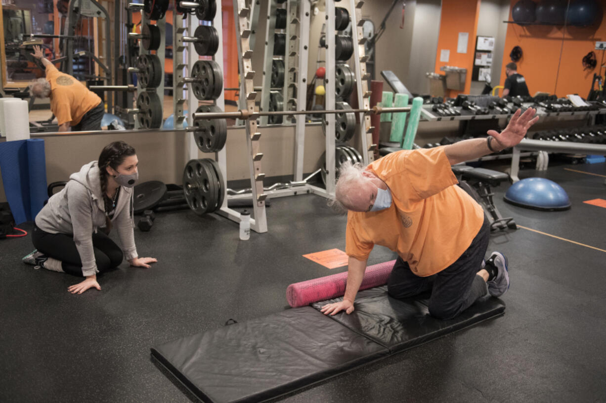 Alicia Rose, left, personal trainer and group fitness instructor at Northwest Personal Training, works with Cliff Miller of Vancouver in downtown Vancouver. Gyms are now open for 25 percent capacity for in-person training.