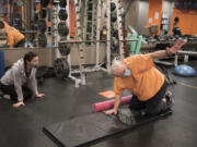 Alicia Rose, left, personal trainer and group fitness instructor at Northwest Personal Training, works with Cliff Miller of Vancouver in downtown Vancouver. Gyms are now open for 25 percent capacity for in-person training.