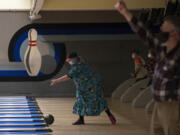 Fran Mesisca of Vancouver, center, goes for a strike while joining fellow bowlers as they get back into action at Hazel Dell Lanes on Wednesday afternoon. Clark County moved to Phase 2 of the state&#039;s reopening plan this week, which allows for the resumption of limited indoor activities at several types of businesses. At top, a sign for AMC theaters outside the Vancouver Mall on Wednesday. AMC&#039;s website states that the two local multiplexes will both reopen Friday.