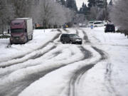 Motorists navigate roads with sketchy winter conditions including snow and ice Monday morning, Feb. 15, 2021.