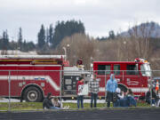 Fans watch from behind a perimeter fence during Saturday&#039;s game between Columbia River and Woodland. The game at Woodland High School was played with limited crowd capacity because of COVID-19 restrictions.