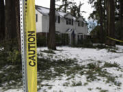 Caution tape surrounds downed branches in front of a house along West 32nd Street in Vancouver on Feb.