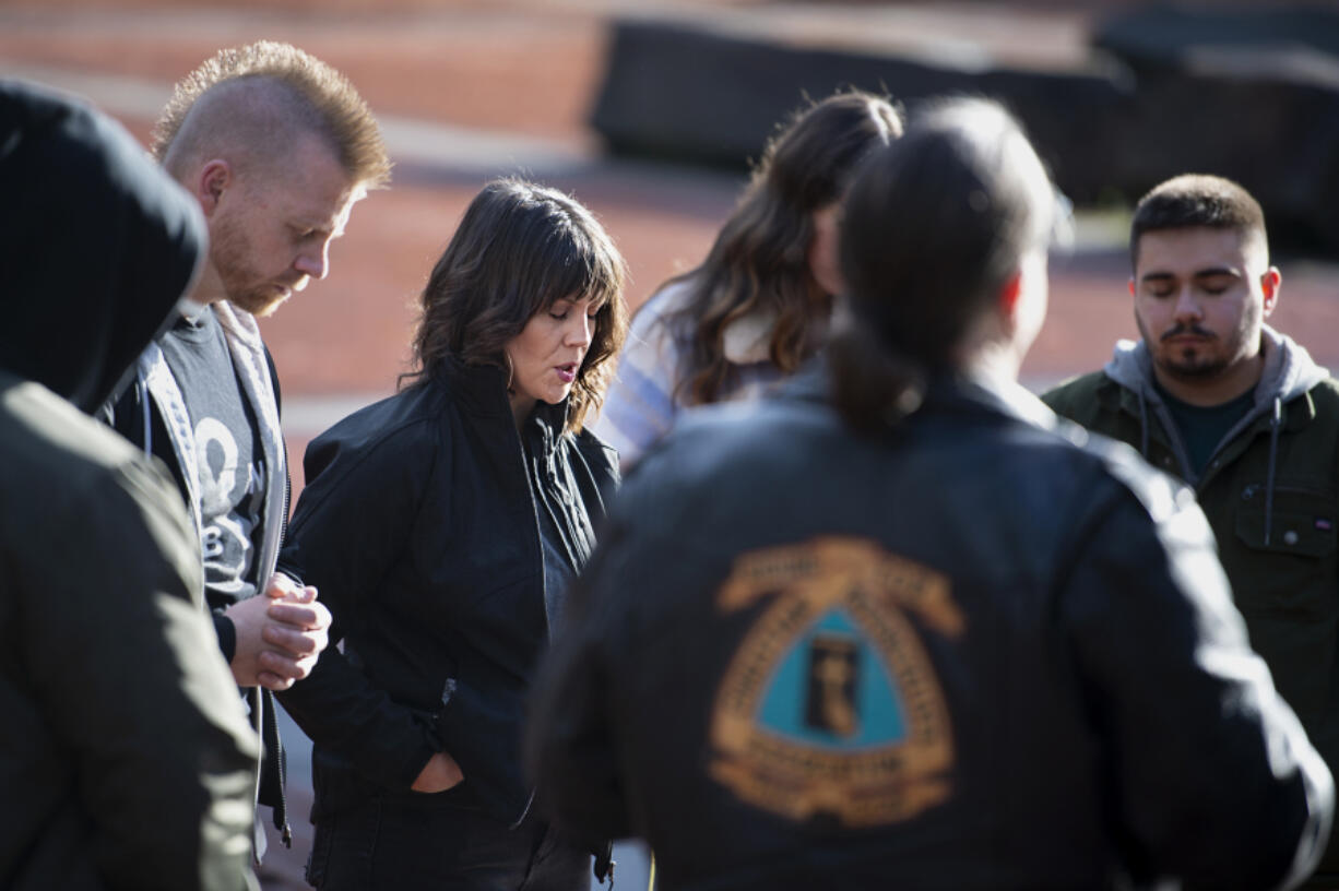 Jenifer O'Neill of Woodland, center, leads the 7CITY PNW Prayer Walk in prayer Saturday at Esther Short Park.