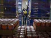 Keith Bunn prepares empty containers for beverage refills at Corwin Distributing in Ridgefield. Corwin Distributing Co. expects to suffer if a new tax on sweetened beverages, introduced in a Washington Senate committee meeting this week, is passed into law.