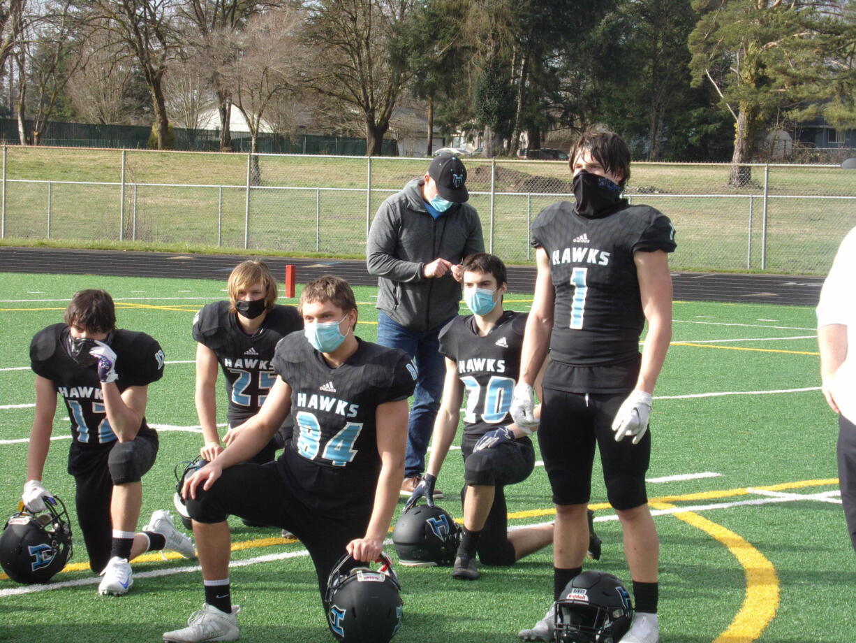 Hockinson junior Andre Northup (1) and his teammates listen to coach Rick Steele after the Hawks' 27-3 win over Woodland on Feb.