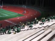 Evergreen football players receive pre-game instruction at their makeshift locker room in the empty stands at McKenzie Stadium (Tim Martinez/The Columbian)